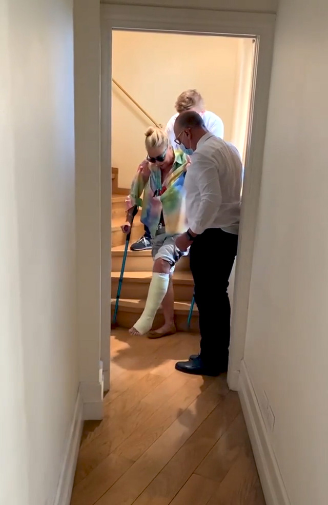 Mara Venier, 69 anni, scende le scale di casa con le stampelle, aiutata dal figlio Paolo